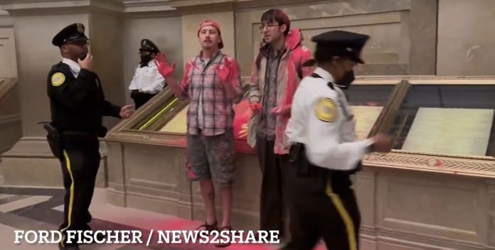 outrageous:-radical-climate-activists-dump-red-powder-on-united-states-constitution-in-rotunda-of-national-archives–-police-stand-around-and-watch