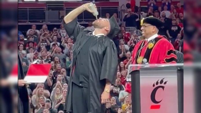 chiefs-star-travis-kelce-chugs-and-slams-beer-on-stage-after-receiving-diploma-from-the-university-of-cincinnati-(video)